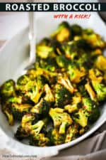 An oval white serving dish filled with roasted broccoli with a kick.