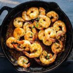 Bake Cajun Baked Shrimp in a black cast iron skillet.