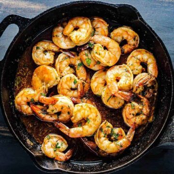 Bake Cajun Baked Shrimp in a black cast iron skillet.