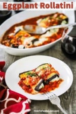 A white plate filled with two baked eggplant rollatini's sitting in front a baking dish of the same.