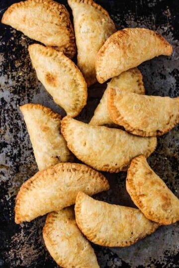 Classic meat pies on a rustic baking sheet