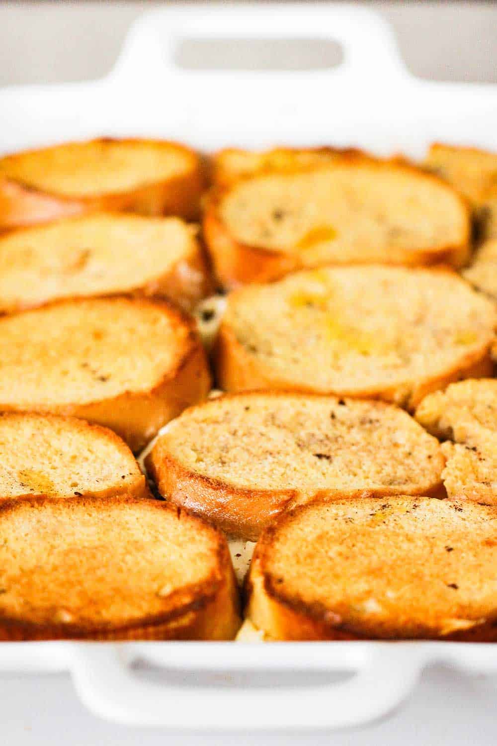 Baked French toast in a large white baking dish. 