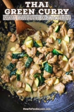An overhead view of a wok filled with Thai green curry chicken with a large wooden spoon inserted on the side.