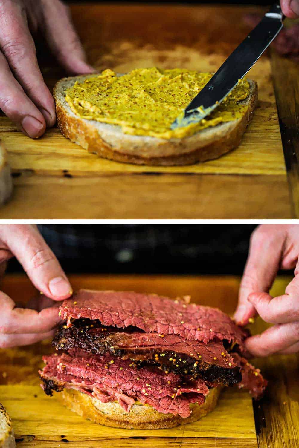 A person smearing on brown mustard onto a slice of rye bread and then adding slices of pastrami on next. 