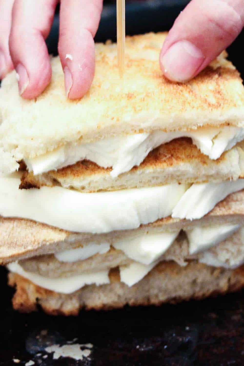 bread and cheese is stacked and held together with a skewer