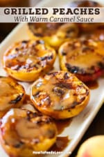 A close-up view of grilled peaches with homemade caramel sauce all on a white rectangular platter.