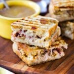 Day After Thanksgiving Panini and a bowl of gravy on a wooden cutting board