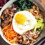 Authentic Bibimbap in a bowl with Korean BBQ sauce and chop sticks