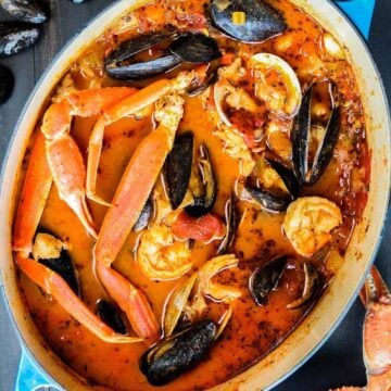 Classic cioppino in a large blue Dutch oven pot