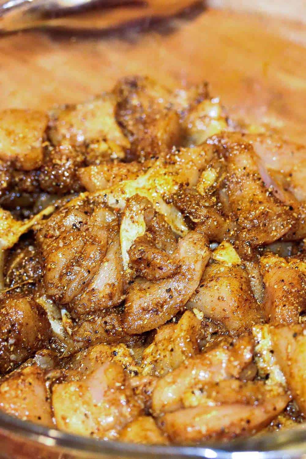 Chicken pieces coasted with spices in a bowl for authentic curry chicken