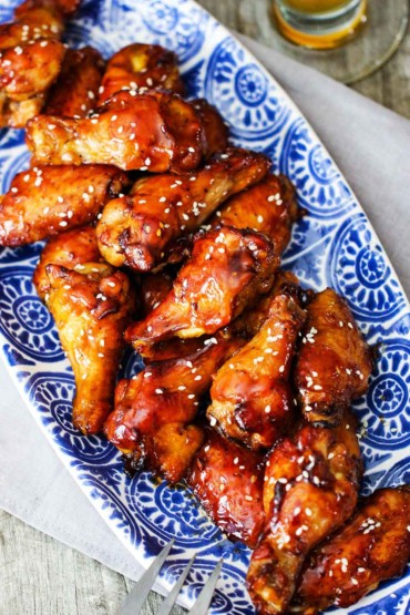A blue platter holding a batch of teriyaki chicken wings.