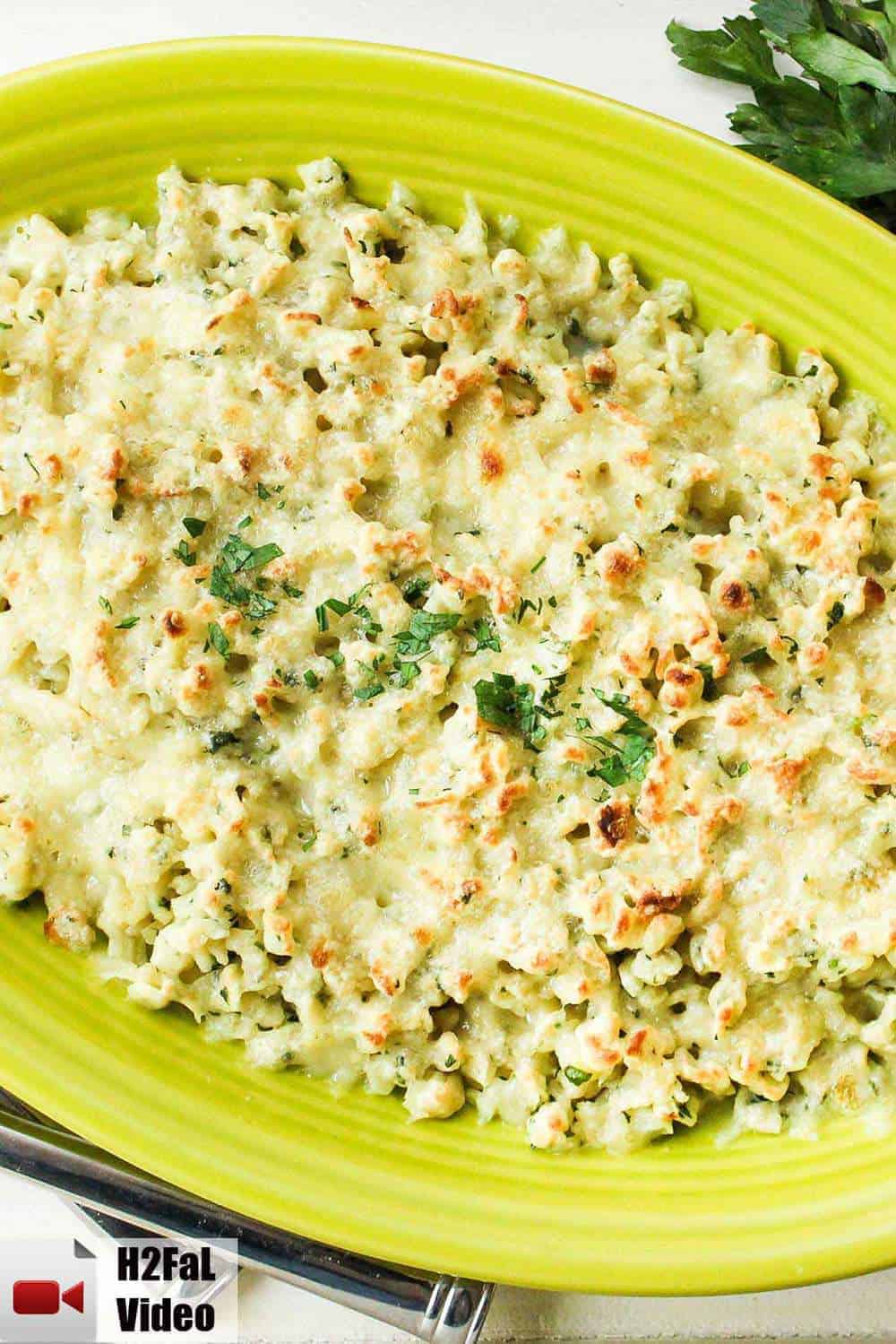 Homemade German spaetzle and cheese on a green platter