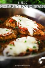 Three chicken parmesan cutlets sitting in a large silver skillet filled with marinara sauce.