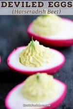 Three horseradish deviled eggs that have a red exterior.
