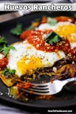 A close-up view of a plate of huevos rancheros with a bite taken out of it.