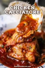 A large silver spoon being used to transfer a tomato, onion, and mushroom sauce onto seared chicken in a bowl.
