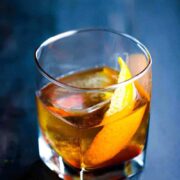 A clear glass filled with an Old Fashion Cocktail