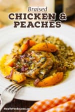 A close-up view a white dinner plate filled with a serving of braised chicken thighs topped with savory peaches served next to wild rice.