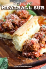 Two meatball sub sandwiches sitting on a cutting board with the top buns revealing the insides of the sandwich.