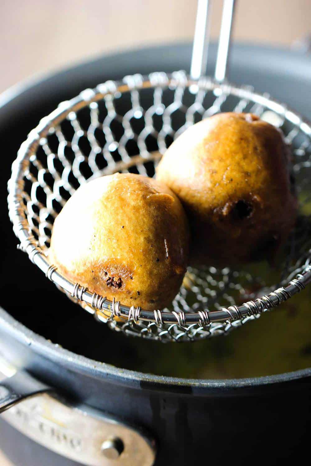 Brownie fritters fresh out of the hot oil in a metal spider