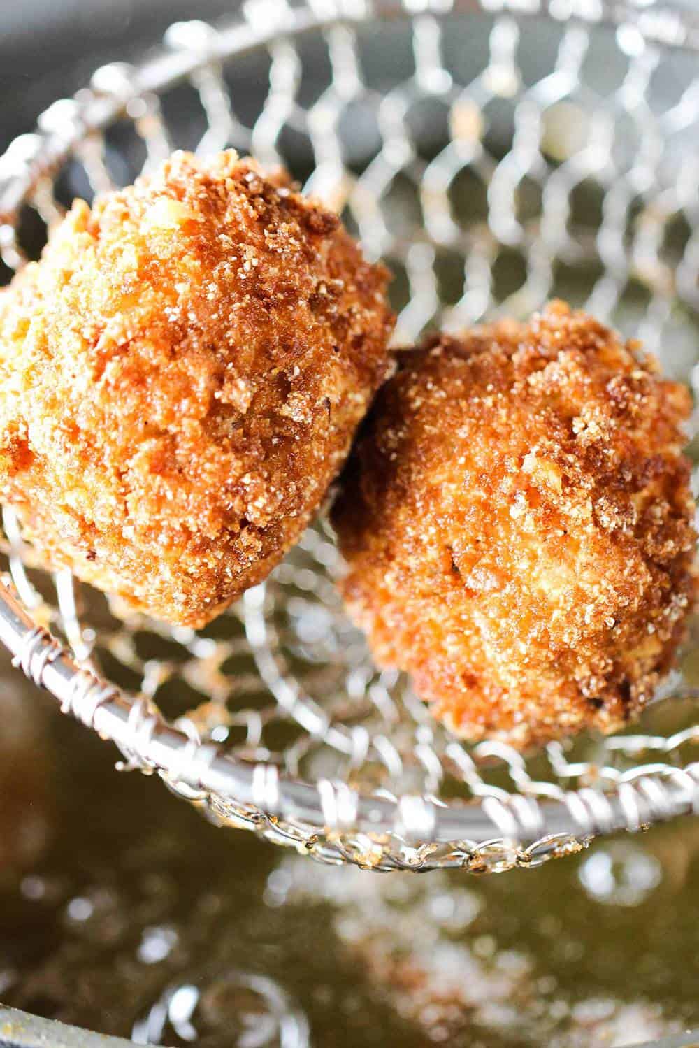 Smoked sausage with cheddar beignets in a basket over a fryer