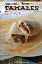 A close-up view of a pork tamale that has been cut in half and one end is resting on the other end so filling is visible.
