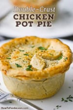 A straight-on view of a homemade chicken pot pie that has not been broken into and is sprinkled with coarse sea salt, black pepper, and finely chopped parsley.