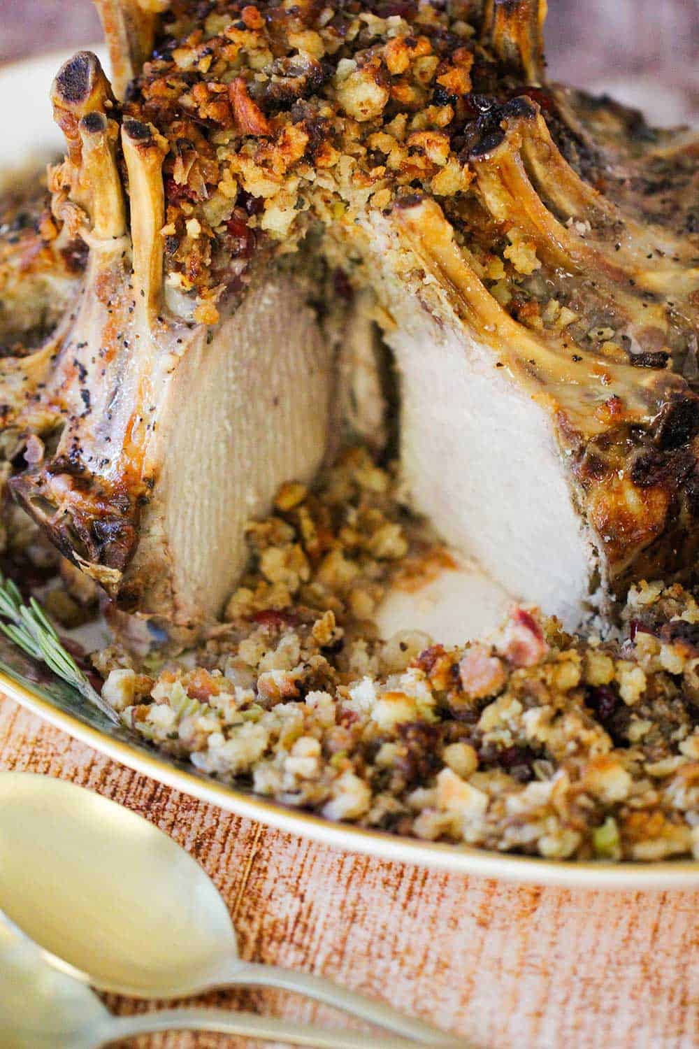 A crown roast of pork on a platter with stuffing. 