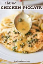 A person using a large spoon to drizzle a lemon sauce over two chicken piccata cutlets on a white plate also with cooked linguine.