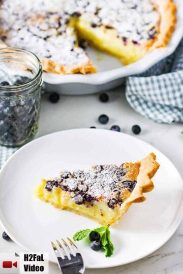 A slice of blueberry buttermilk pie on a white plate