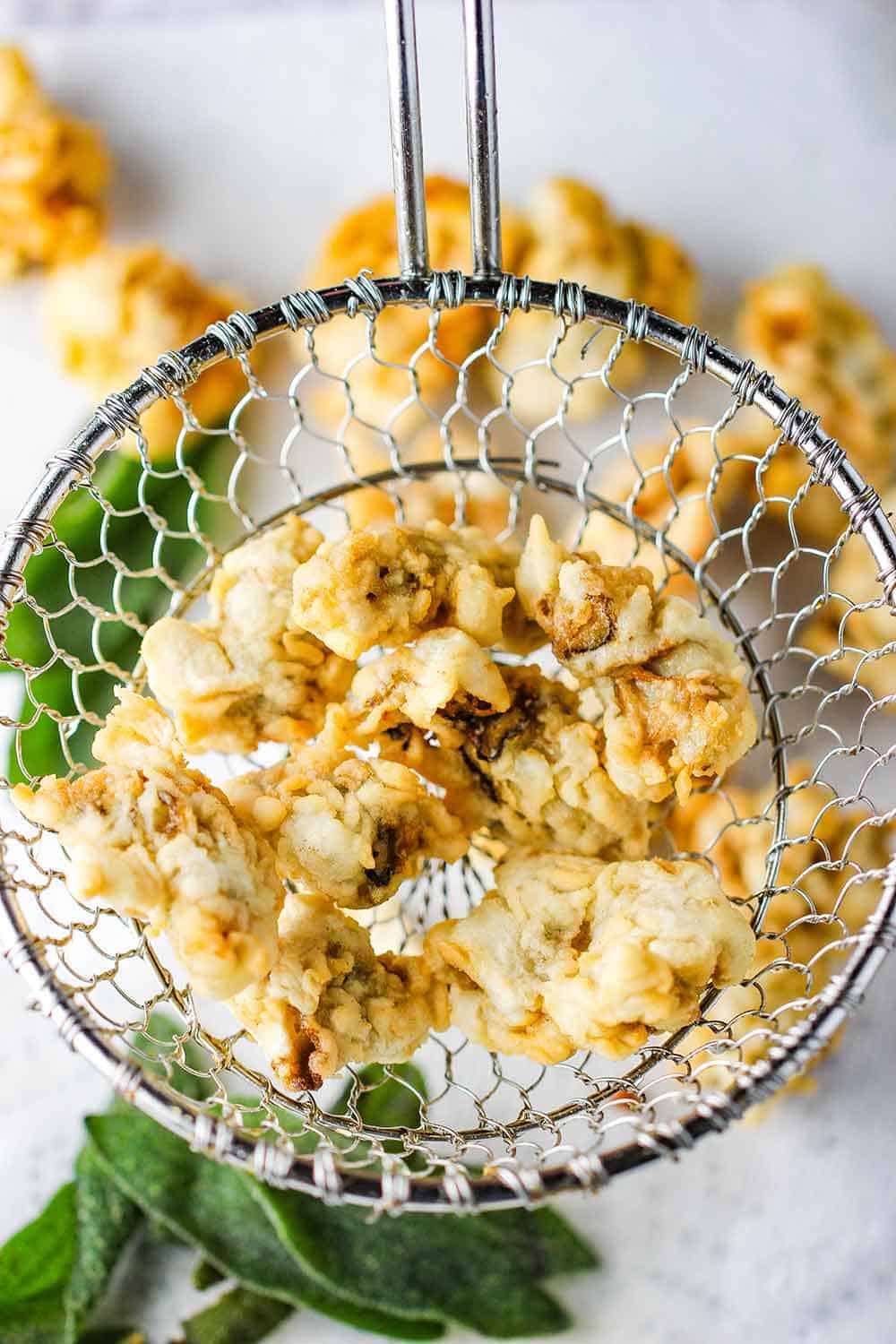 A wire spider holding fried oysters.