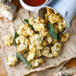 A turned-over bucket with fried oysters and clams paling out of the pale.