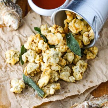 A turned-over bucket with fried oysters and clams paling out of the pale.