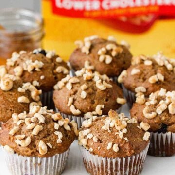 Place the baked banana blueberry muffins on a platter next to a box of Honey Nut Cheerios.