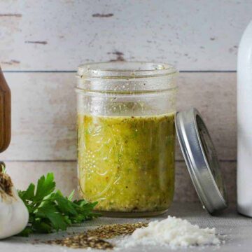 A mason jar filled with homemade Italian dressing.