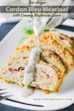 A gravy boat pouring a creamy mushroom sauce over a cordon bleu meatloaf.