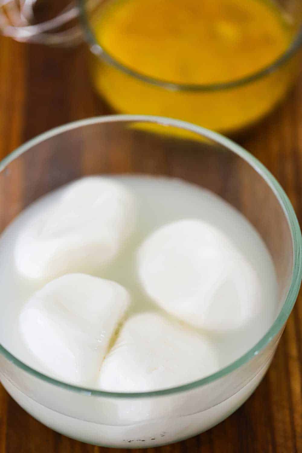 A medium-sized glass bowl filled with buratta cheese and water.