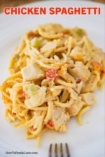 A white dinner plate filled with a large helping of chicken spaghetti.