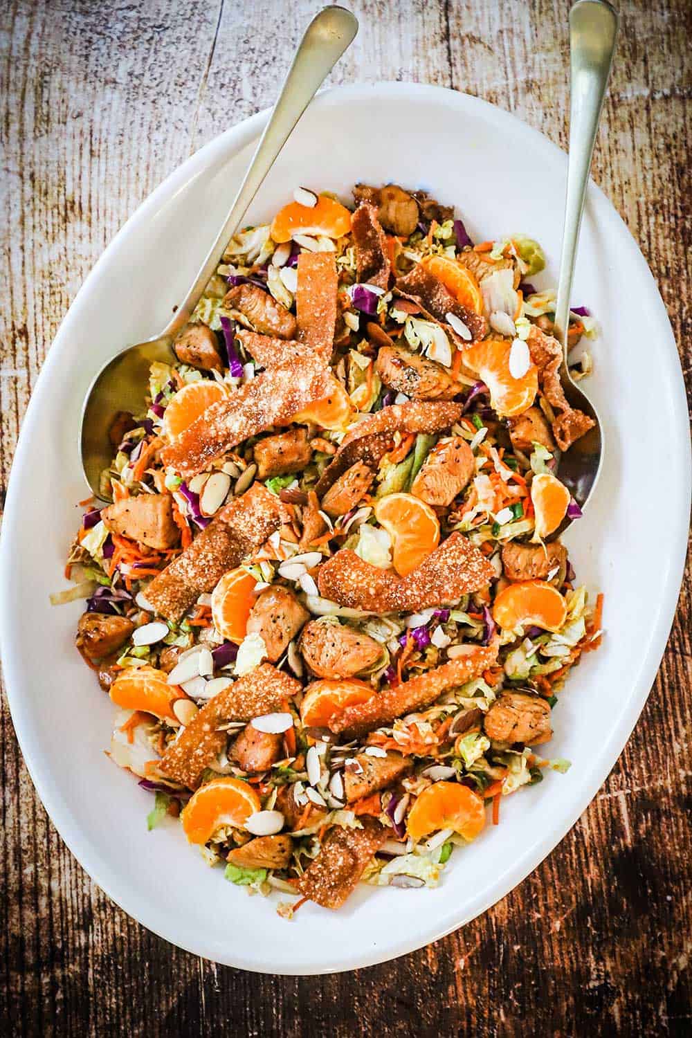A large oval white platter holding a Chinese chicken salad.