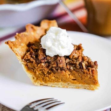 A slice of sweet potato pie sitting on a white dessert plate next to the pie in a pie dish.