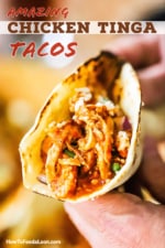 A person holding a chicken tinga taco in a grilled flour tortilla.