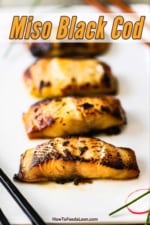 Four miso black cod fillets on a white rectangular platter.
