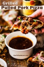 A person holding a slice of pulled pork pizza with a bite taken out of it and held above a small bowl of barbecue sauce.