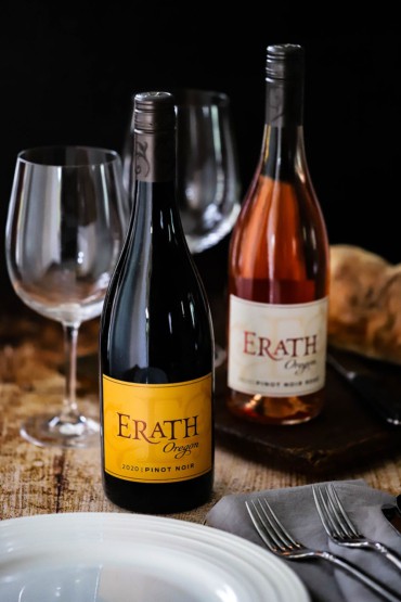 A straight-on view of a bottle of Erath Pinot Noir wine and a bottle of Erath Rosé in the background.