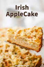A slice of Irish apple cake being raised up the entire cake on a silver pie slicer.