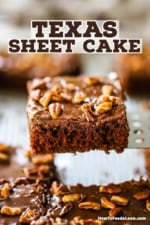 A square slice of Texas sheet cake being raised from the pan with a metal spatula.