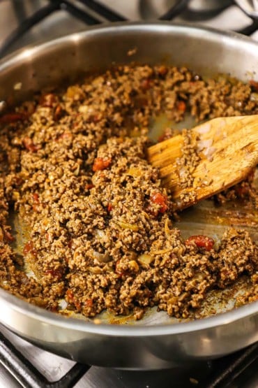 An overhead view of a large stainless steel skillet filled with homemade ground beef taco meat.