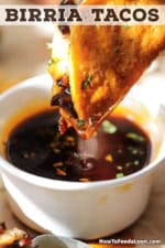 A close-up view of a beef birria taco that is being dipped into a small bowl of beef consommé.