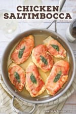 An overhead view of six fully cooked chicken saltimbocca cutlets in a skillet that are topped with crispy prosciutto and a sage leaf all resting in a white wine butter sauce.
