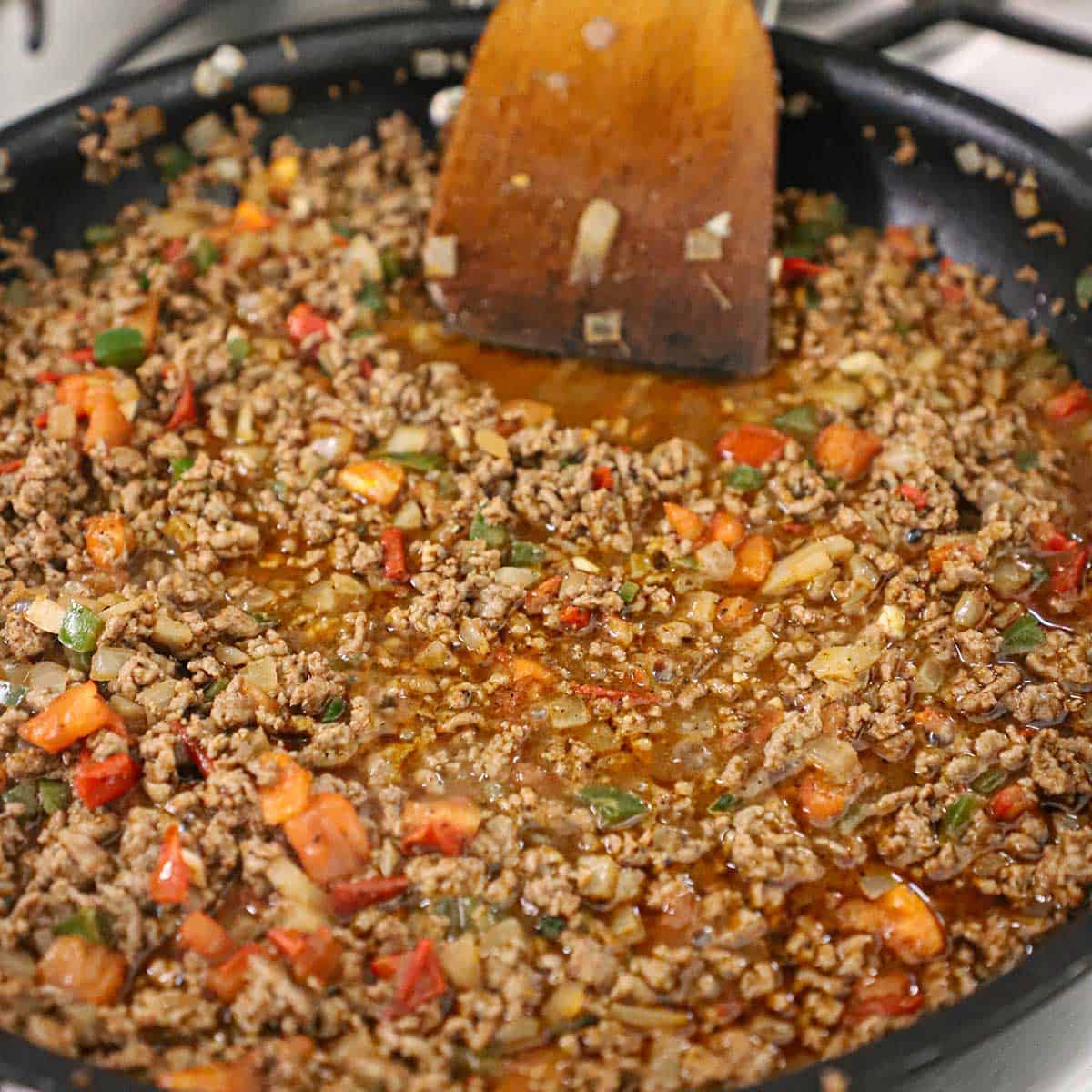 A large skillet filled with simmering taco meat. 